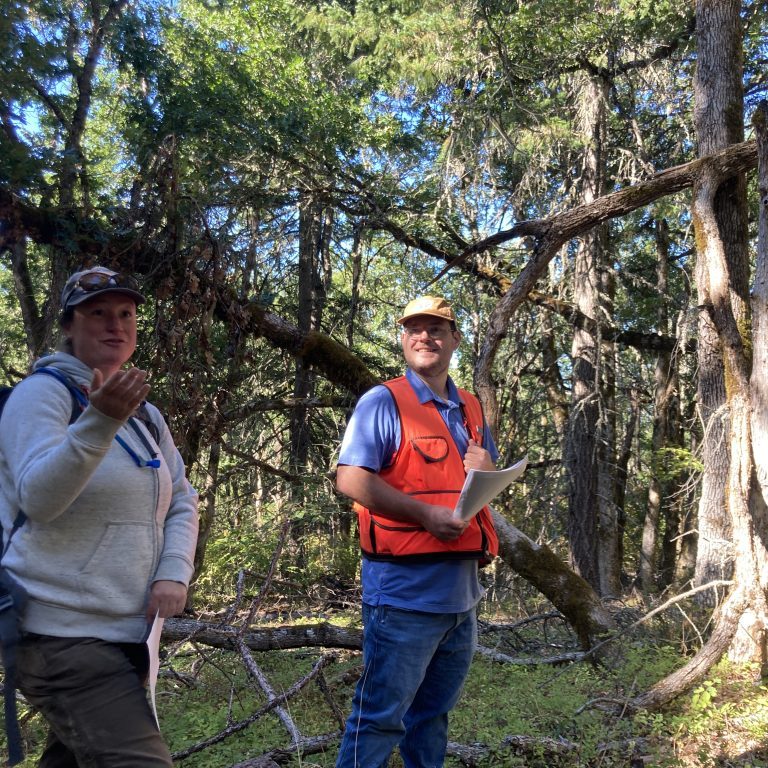 Two Department of Natural Resource employees standing in front of oak trees